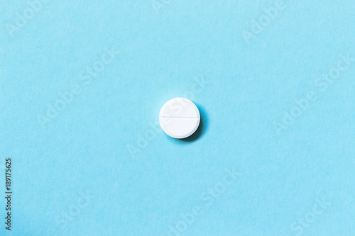 Single white pills on a blue background. Medications. Flat lay. Concept medicine