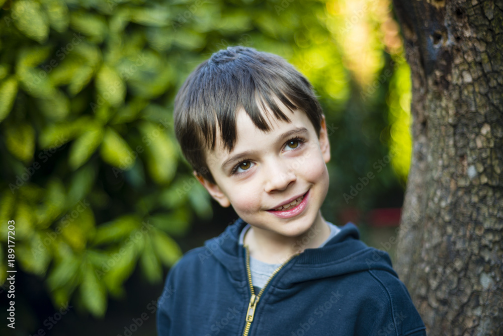 portrait of 7 year old boy outdoor in the garden in winter portrait of 7 year old boy outdoor in the garden in winter