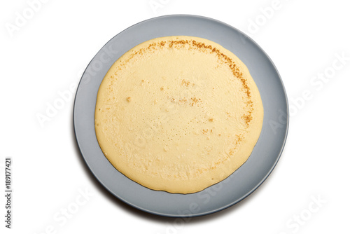 Pancake on blue plate with natural shadow isolated on white