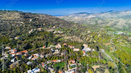 Aerial bird eye view of Miliou village hills and Akamas sea at Latchi, Paphos Cyprus. View of traditional ceramic tile roof houses near Ayii Anargyri monastery nature hotel spa from above. photo