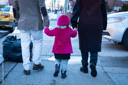 Child holding hands with parents