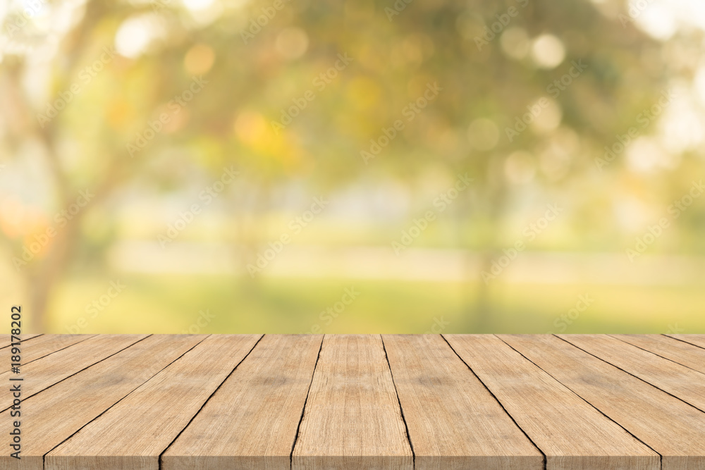 Empty wood table top on nature green blurred background at garden,space for montage show products Empty wood table top on nature green blurred background at garden,space for montage show products