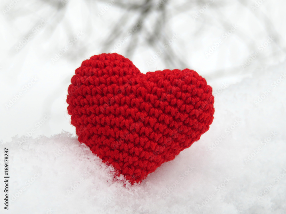 Fototapeta premium Donation background. Knitted heart in the snow on winter background. Love concept
