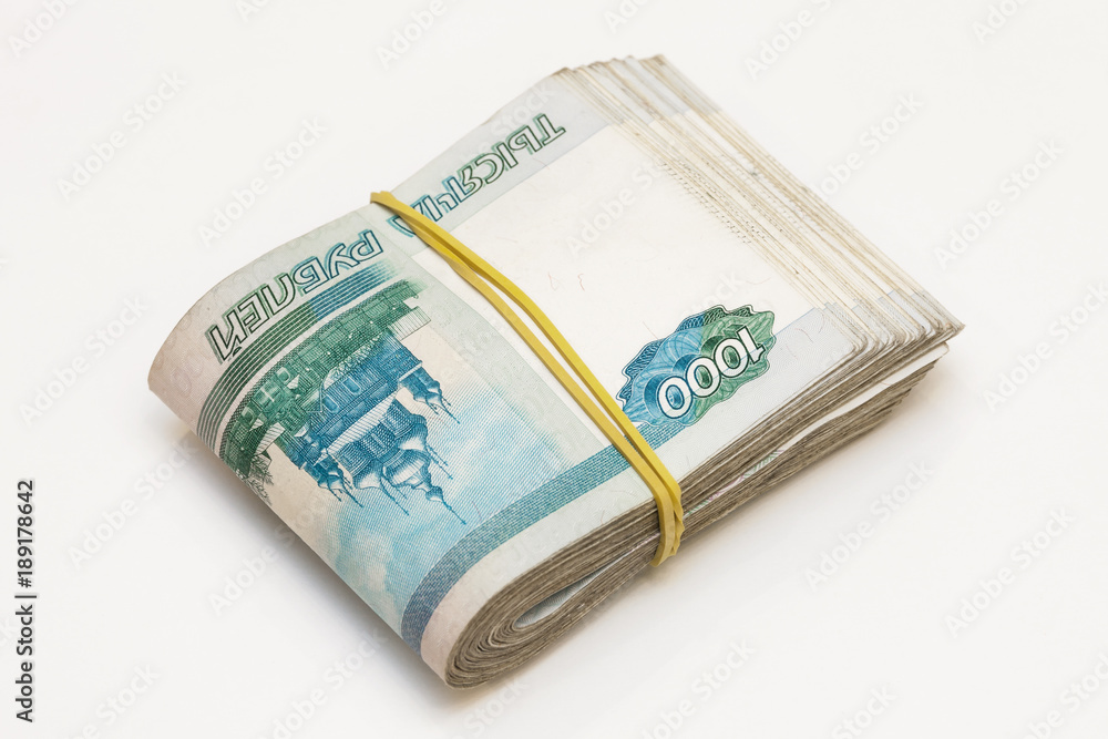 Bundle of banknotes of 1000 rubles stretched with an elastic band on the light background Bundle of banknotes of 1000 rubles stretched with an elastic band on the light background