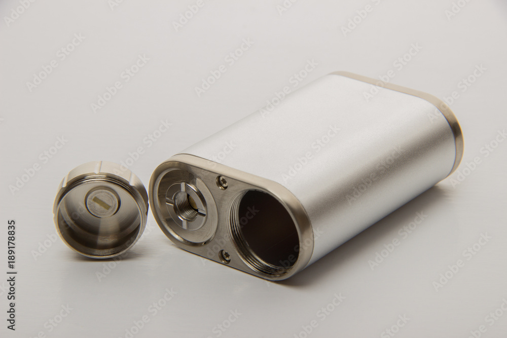 Dismantled parts of the electronic cigarette black and steel colors on a background Dismantled parts of the electronic cigarette black and steel colors on a background