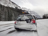Icefields Parkway in winter with the snowy rocky mountains towering around.