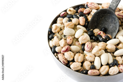 Uncooked assorted legumes with spoon in metal bowl isolated on white background. Copyspace