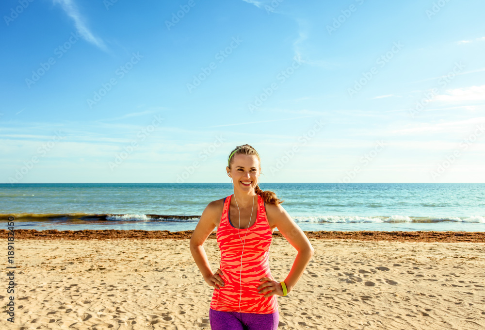 smiling healthy fitness woman on beach looking into distance smiling healthy fitness woman on beach looking into distance