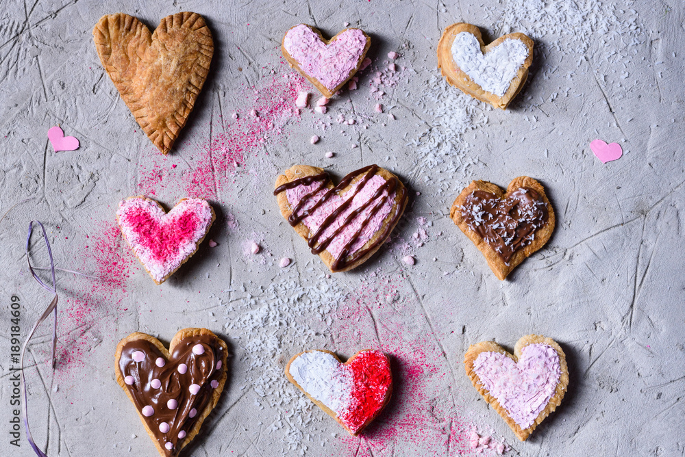 top view of various sweet heart shaped valentines cookies on grey surface