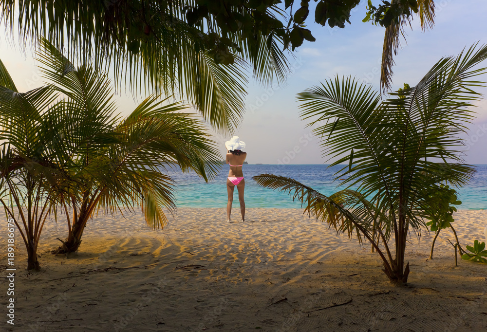 Sonnenuntergang am Maledivenstrand mit Bikinimodel