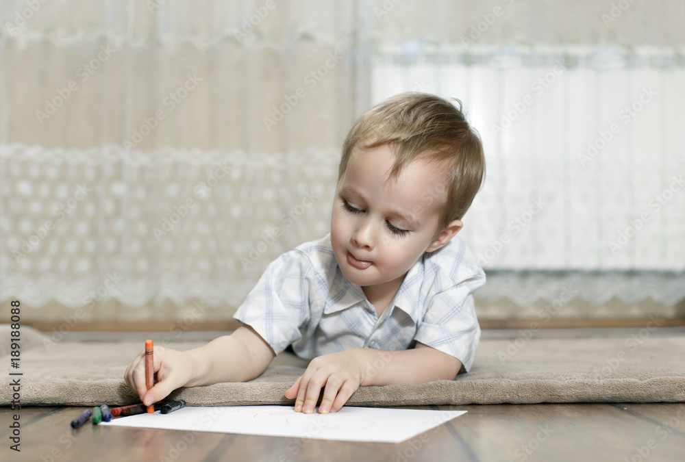 little boy draws with colorful pencils lying on the floor little boy draws with colorful pencils lying on the floor