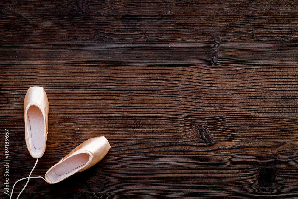 Ballet pointe shoes on dark wooden background top view copy space Ballet pointe shoes on dark wooden background top view copy space