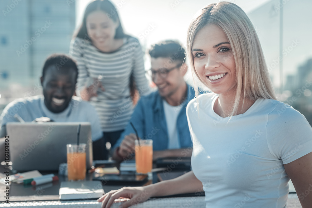 Always work together. Waist up shot of a young woman smiling into the camera while meeting with her college friends and studying together. Always work together. Waist up shot of a young woman smiling into the camera while meeting with her college friends and studying together.