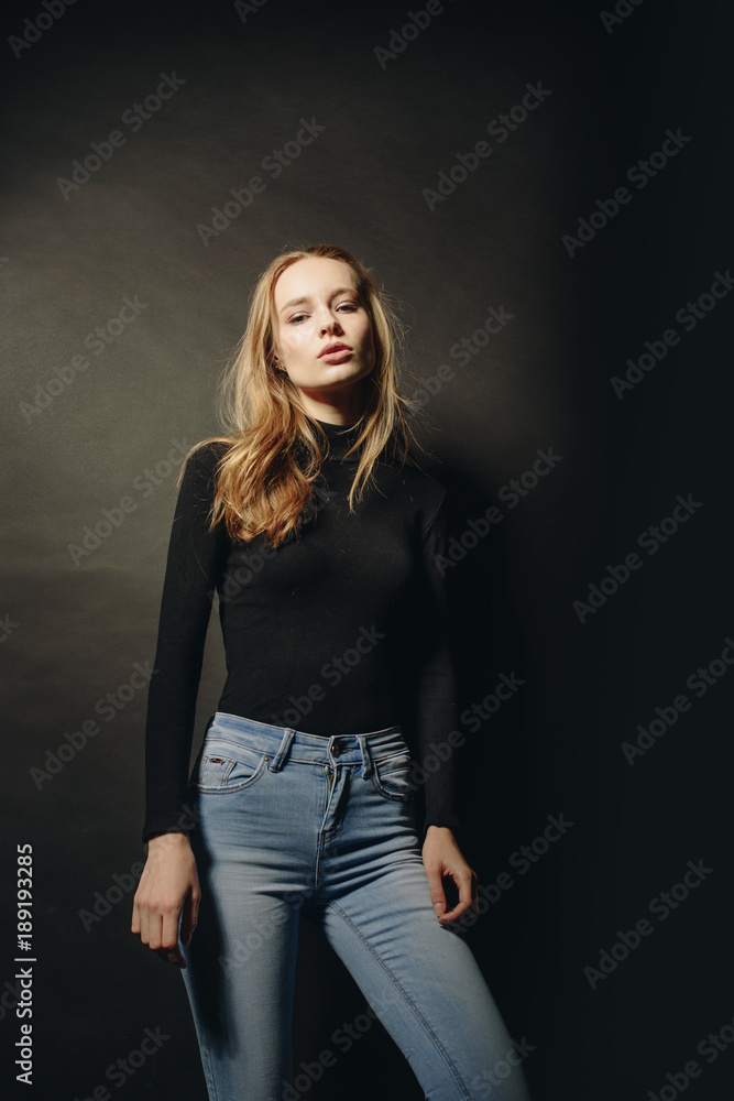 Technical woman. Naturally beautiful. Attractive young woman looking at camera while standing against black background Technical woman. Naturally beautiful. Attractive young woman looking at camera while standing against black background