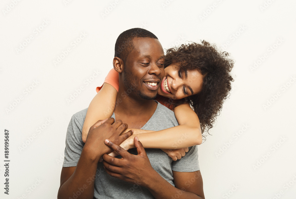 Black couple hugging and posing at white background Black couple hugging and posing at white background