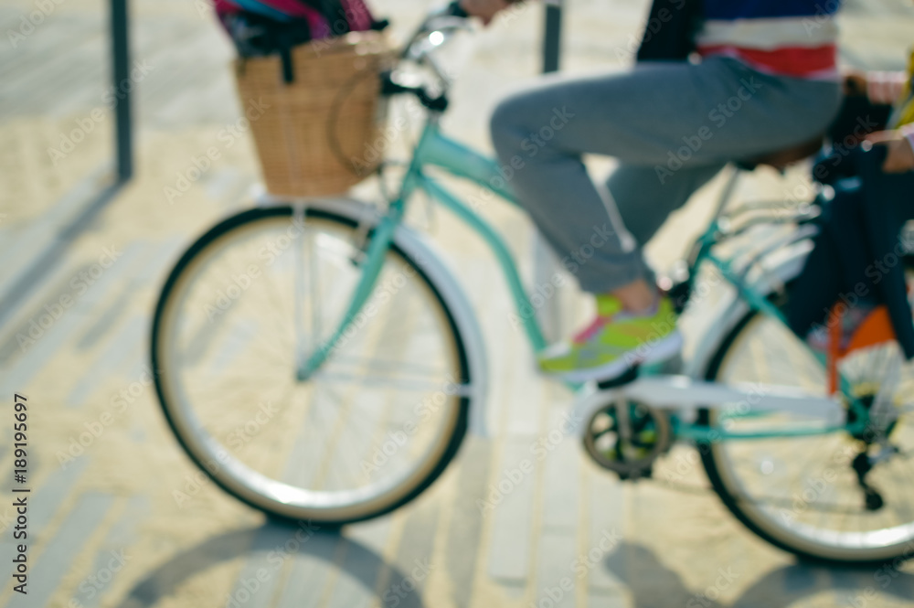 Obraz premium Blurred outdoors image of active family bike ride. Mother and child biking on outside nature background. Healthy activity lifestyle, having fun travel vacation