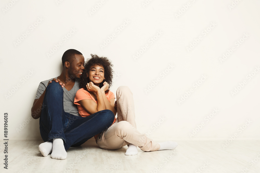 African-american couple looking up, sitting on floor African-american couple looking up, sitting on floor