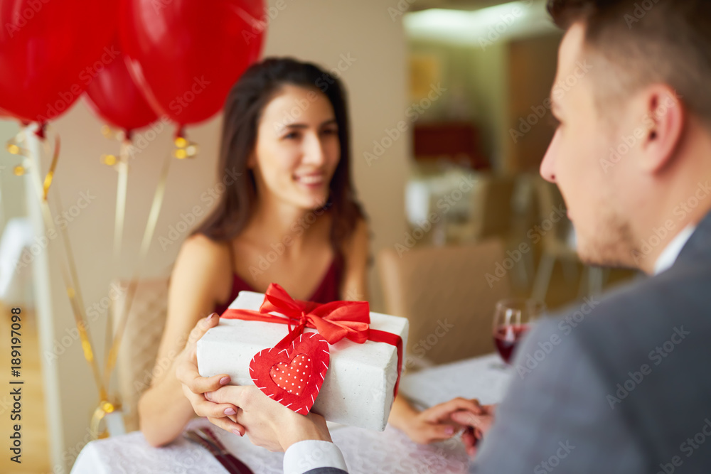 Valentine's Day concept. Happy couple in love with. A young loving couple celebrating Valentine's Day in the restaurant. Lovers give each other gifts. Romance restaurant for Valentine's Day- concep
Valentine's Day concept. Happy couple in love with. A young loving couple celebrating Valentine's Day in the restaurant. Lovers give each other gifts. Romance restaurant for Valentine's Day- concep