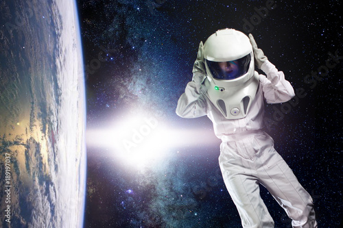 Fototapeta Naklejka Na Ścianę i Meble -  Astronaut in space, in zero gravity near the planet Earth. The concept, find a new earth. Elements of this image furnished by NASA.