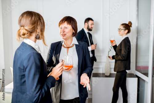 Business people talking during the meeting standing with drinks in the office