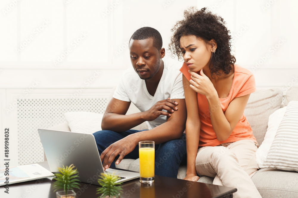 Young african-american couple working on laptop, copy space Young african-american couple working on laptop, copy space
