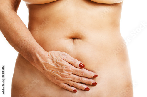 Senior woman touching abdomen over white background