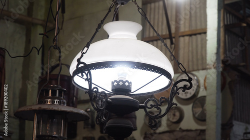 An old, vintage lamp with a shade in an antique store.