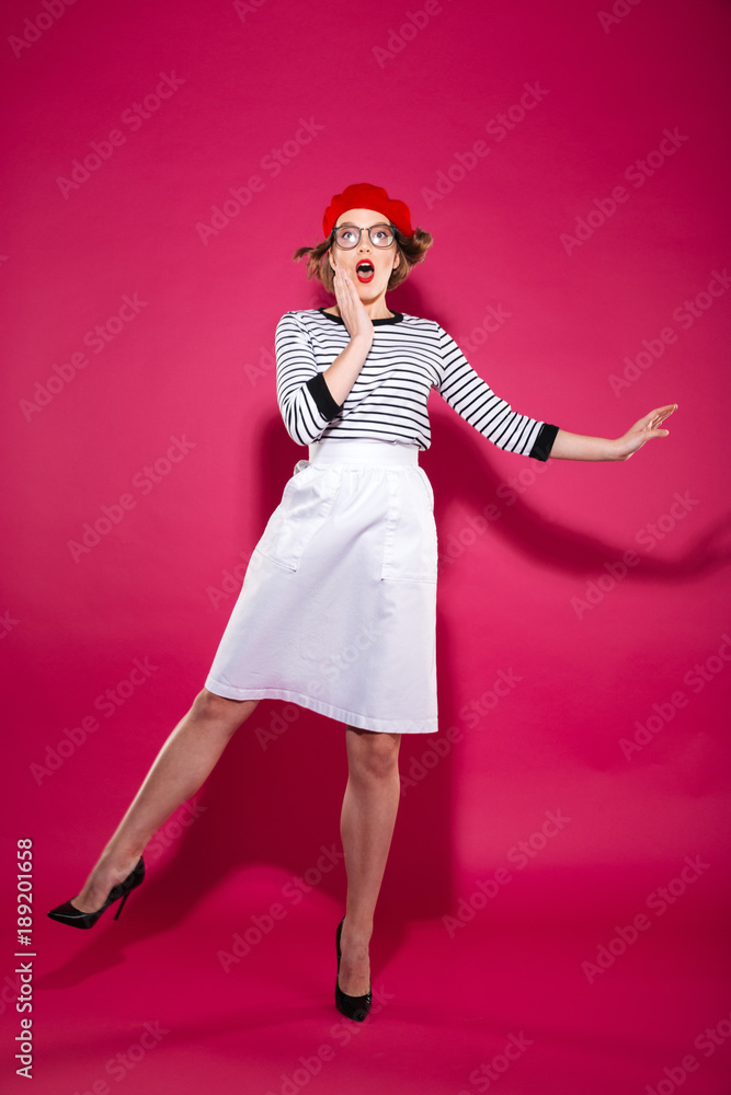 Full length image of Shocked woman in eyeglasses holding cheek Full length image of Shocked woman in eyeglasses holding cheek
