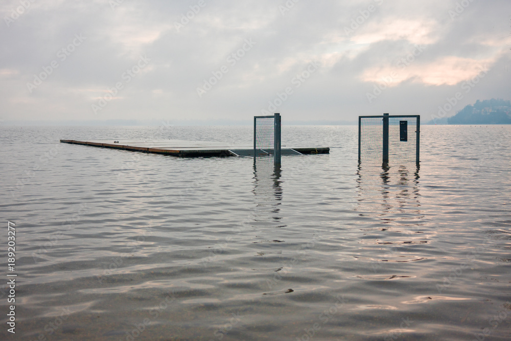 jetty and gates submerged by the waters of the lake, on a winter day jetty and gates submerged by the waters of the lake, on a winter day