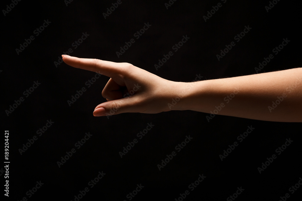 Hand gestures - woman pointing, isolated at black