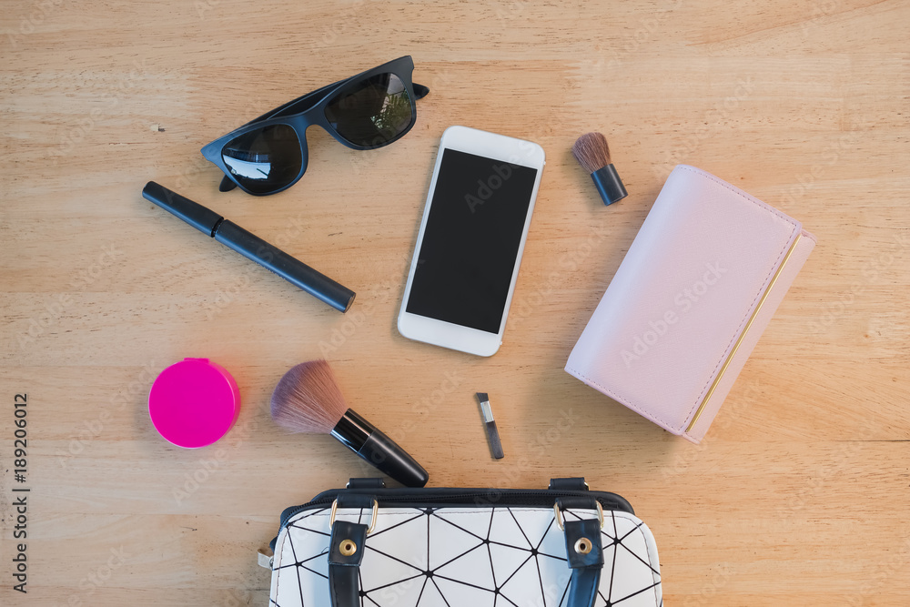 Top view of Women bag and lady stuff with copyspace on wooden background Top view of Women bag and lady stuff with copyspace on wooden background