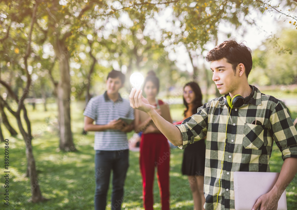 Fototapeta premium man teen student holding to the illuminated bulb .Light Bulb Think Ideas Create