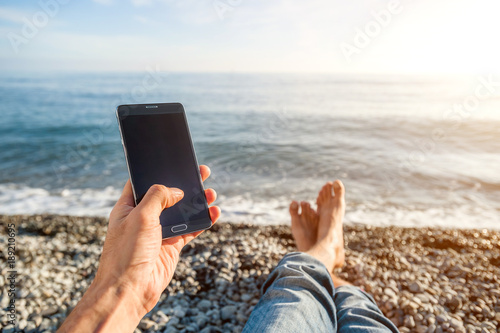 Guy on the beach with phone