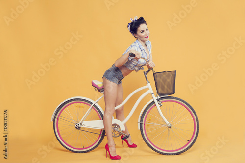 Fototapeta Naklejka Na Ścianę i Meble -  girl with beautiful legs on the bike