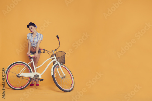 the girl leans on a seat of a Bicycle