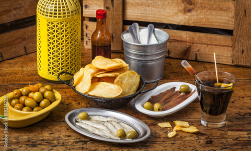 Fotografie Spanish vermouth with tapas on a vintage wooden table.
