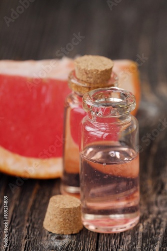 Pink grapefruit oil and fruit on the table