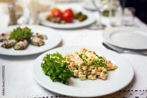 Traditional Russian Salad also called Olivier salad on a vintage wooden table