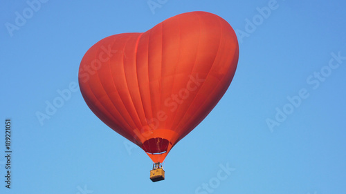 Hot air balloon shape of a heart in the blue sky. Aerostat  Airship. Red balloon.