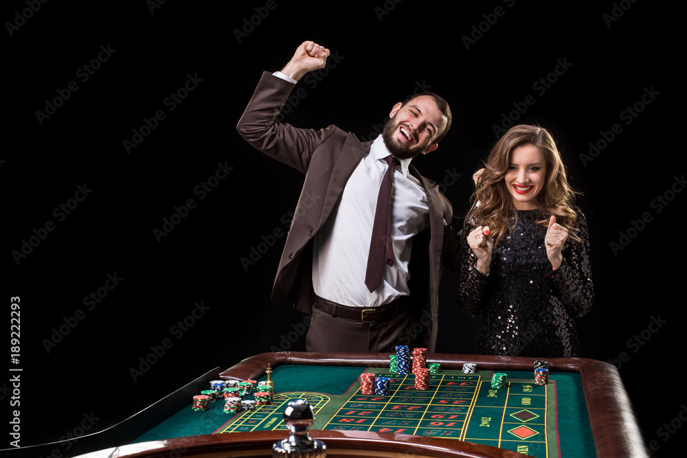 Man and woman playing at roulette table in casino Man and woman playing at roulette table in casino