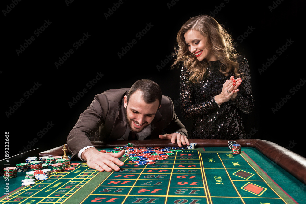Man and woman playing at roulette table in casino Man and woman playing at roulette table in casino
