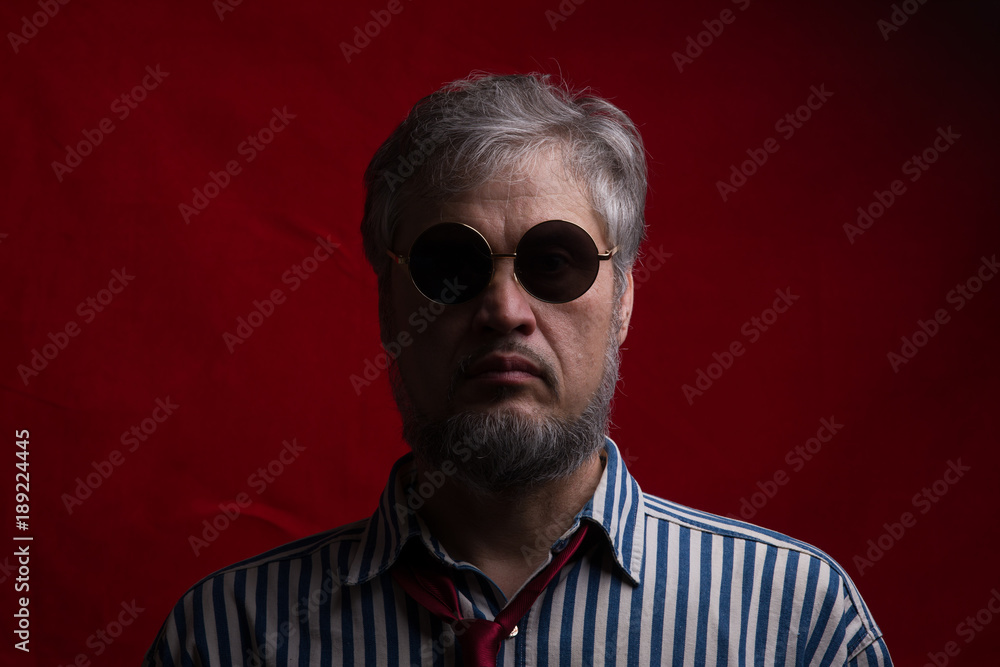 dark portrait of a bearded man on a red background dark portrait of a bearded man on a red background
