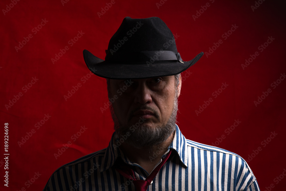 male cowboy portrait on a red background male cowboy portrait on a red background