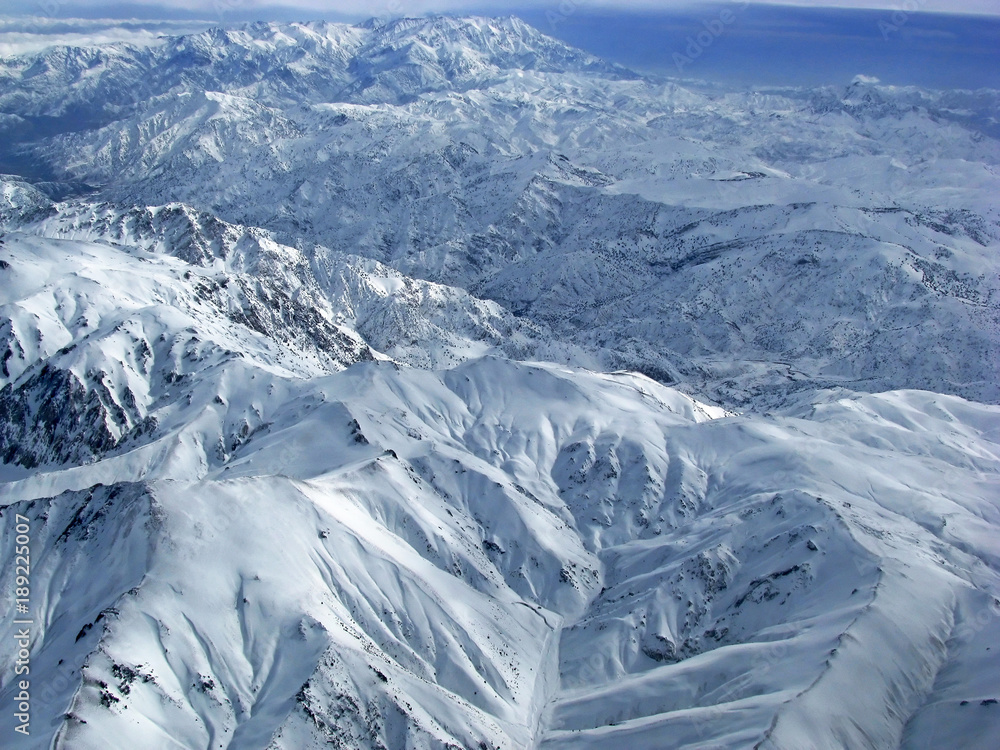 Fototapeta premium Hindu Kush Mountains - snow-covered peaks of mountains seen from the plane
