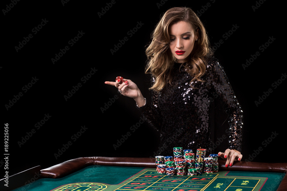 Woman playing in casino. Woman stakes piles of chips playing rou Woman playing in casino. Woman stakes piles of chips playing rou
