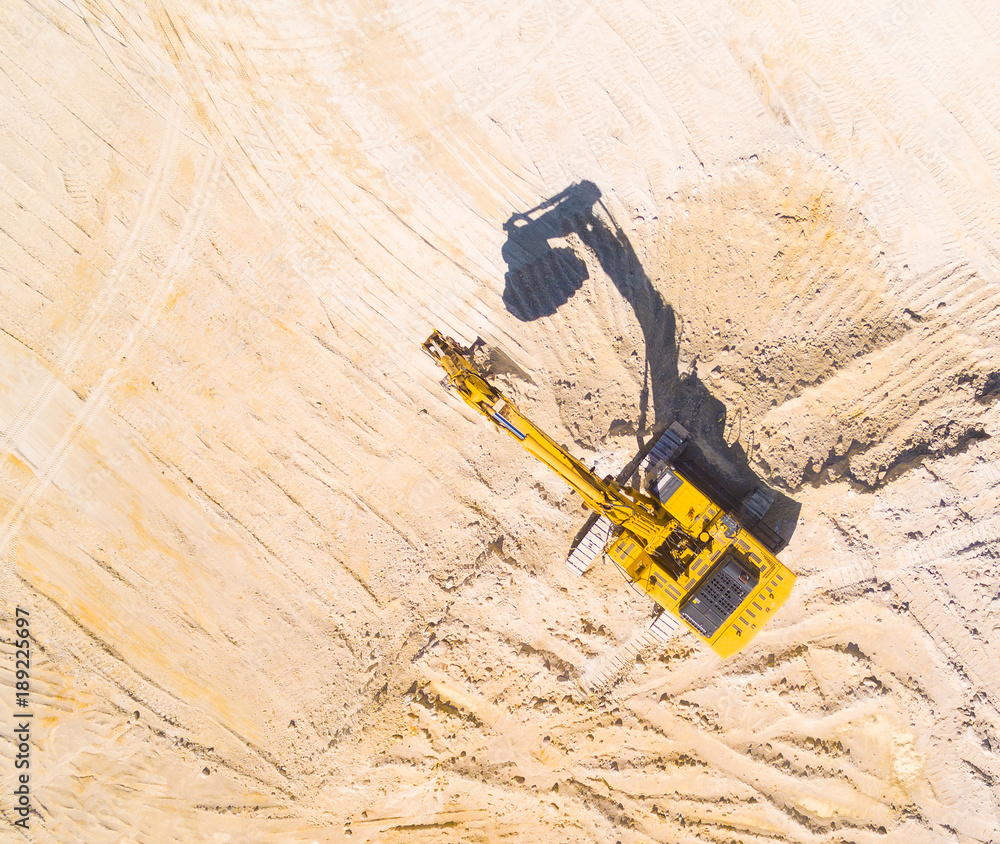 Aerial view of a excavator in the mine or construction site. Heavy industry and machinery. Industrial background on mining theme. 