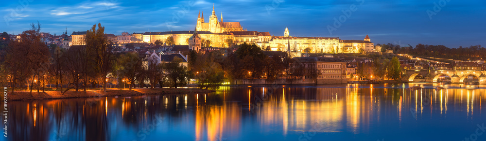 Large panorama of Prague, view of illuminated Prague castle (Prazsky Hrad) with reflection in the water, night scenic cityscape, world famous historical heritage of Czech Republic