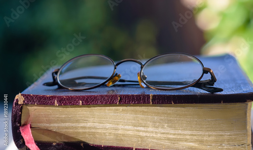 Glasses rest on top of old leather bible
