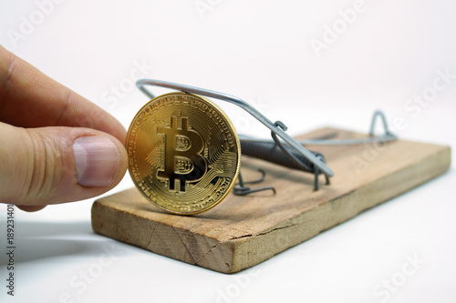 a hand that takes bitcoin from a mousetrap