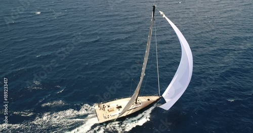 Aerial view of a sailing boat navigating with open sails.